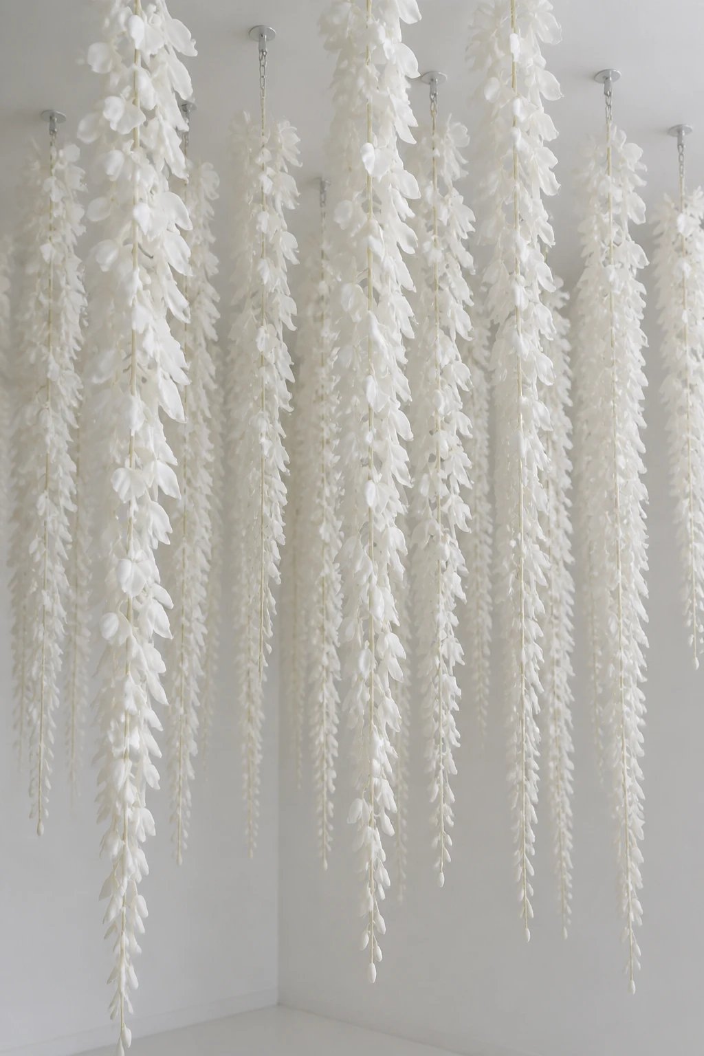 White latex wisteria strands cascading from ceiling hooks