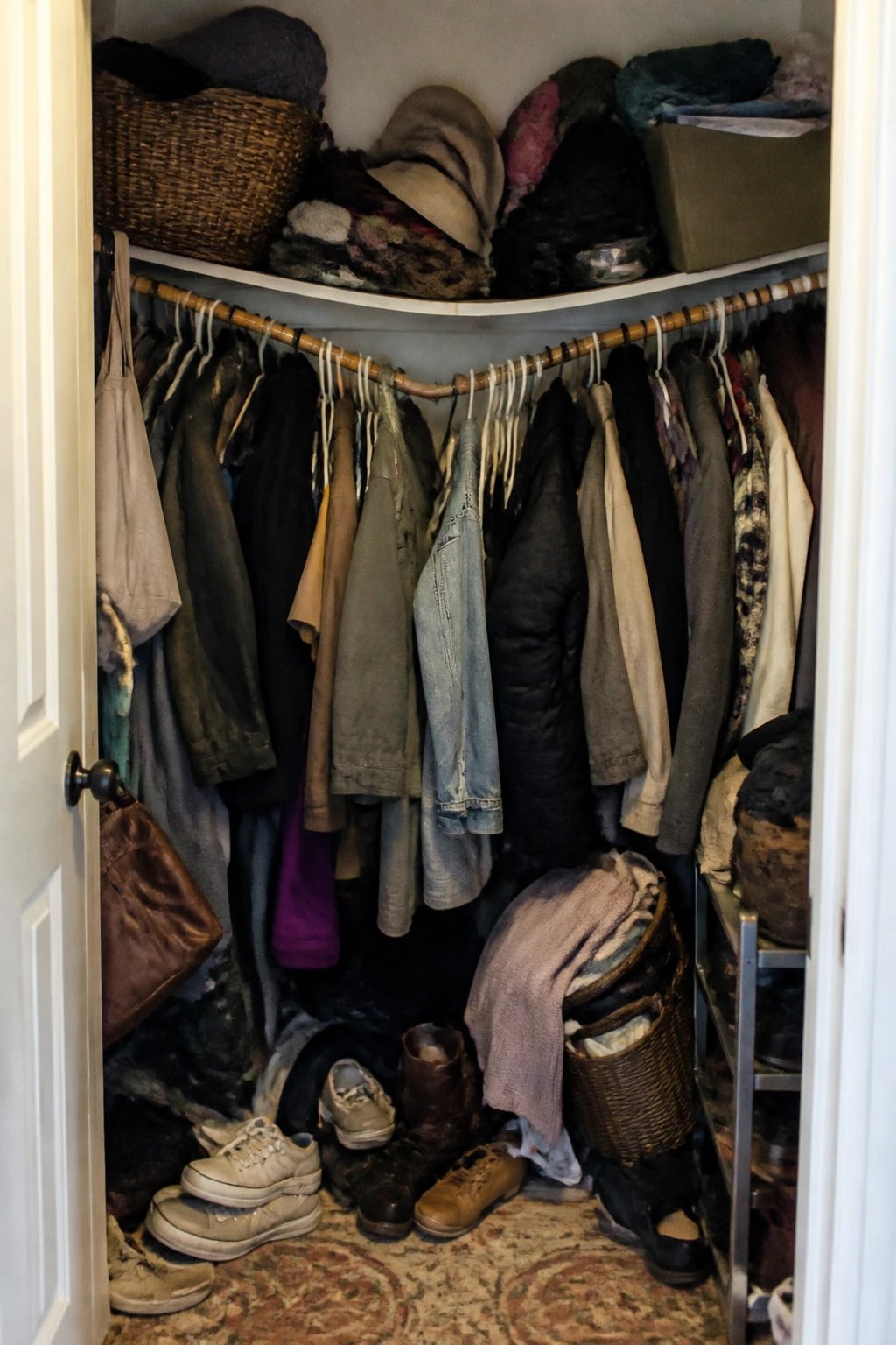 cluttered entry closet with sagging rod